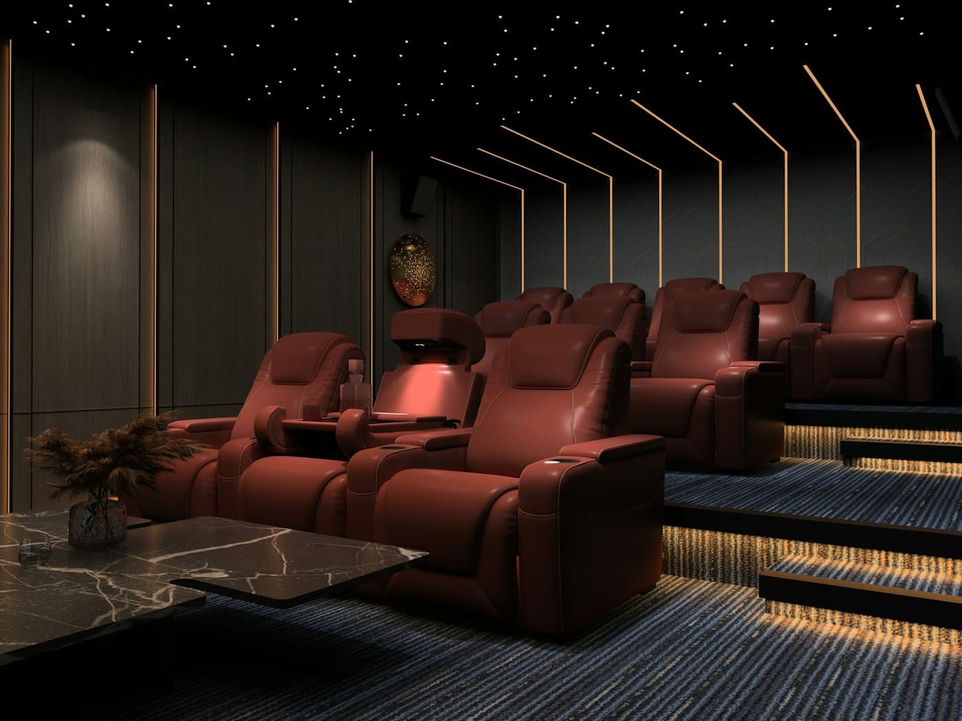 A dark home cinema with tiered red leather recliners, a fibre-optic star ceiling and warm LED strip lighting.